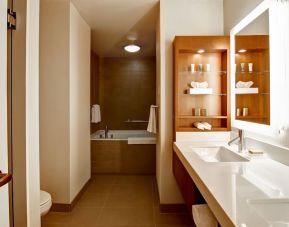 Private guest bathroom with tub and toiletries at Hilton Mississauga Meadowvale.