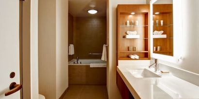 Private guest bathroom with tub and toiletries at Hilton Mississauga Meadowvale.