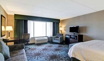 Day use room with TV, work desk and lounge area at Hampton Inn By Hilton Toronto Airport Corporate Centre.