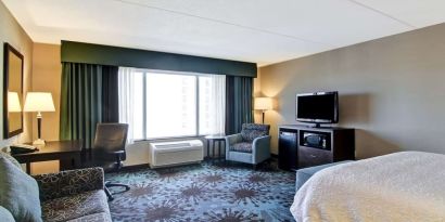 Day use room with TV, work desk and lounge area at Hampton Inn By Hilton Toronto Airport Corporate Centre.