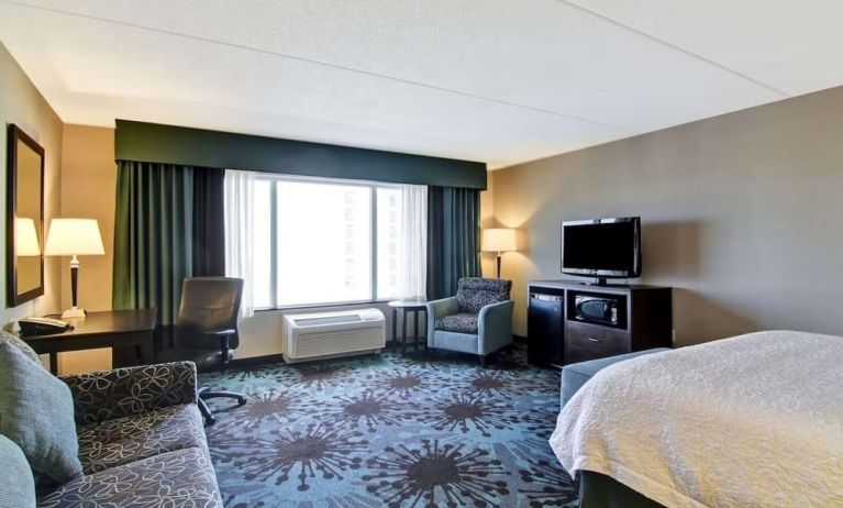 Day use room with TV, work desk and lounge area at Hampton Inn By Hilton Toronto Airport Corporate Centre.