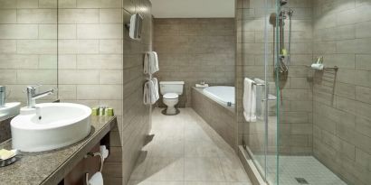 Private guest bathroom with shower, tub and free toiletries at DoubleTree By Hilton Montreal.