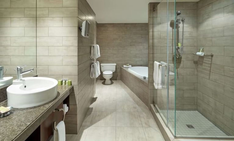 Private guest bathroom with shower, tub and free toiletries at DoubleTree By Hilton Montreal.