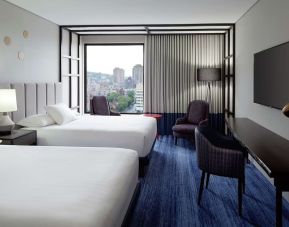 Twin day use room with work desk, lounge area and window view at DoubleTree By Hilton Montreal.