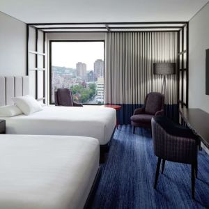 Twin day use room with work desk, lounge area and window view at DoubleTree By Hilton Montreal.