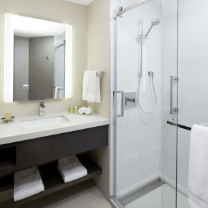 Private guest bathroom with shower and free toiletries at DoubleTree By Hilton Montreal.