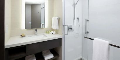 Private guest bathroom with shower and free toiletries at DoubleTree By Hilton Montreal.