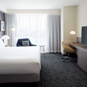 Day use room with king bed, TV, work desk and lounge area at Hilton Garden Inn Montreal Midtown.