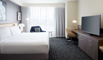 Day use room with king bed, TV, work desk and lounge area at Hilton Garden Inn Montreal Midtown.