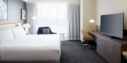 Day use room with king bed, TV, work desk and lounge area at Hilton Garden Inn Montreal Midtown.