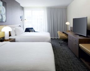 Day use twin room with TV, work desk and lounge area at Hilton Garden Inn Montreal Midtown.