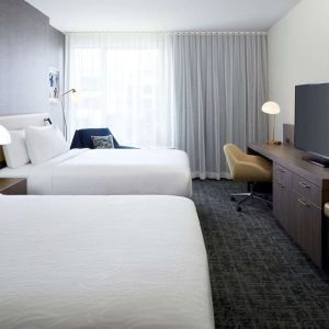 Day use twin room with TV, work desk and lounge area at Hilton Garden Inn Montreal Midtown.