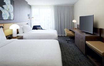 Day use twin room with TV, work desk and lounge area at Hilton Garden Inn Montreal Midtown.