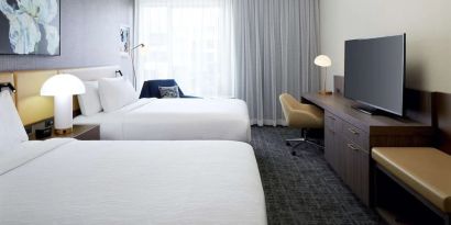 Day use twin room with TV, work desk and lounge area at Hilton Garden Inn Montreal Midtown.