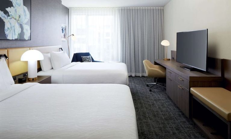 Day use twin room with TV, work desk and lounge area at Hilton Garden Inn Montreal Midtown.