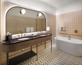 Private bathroom with tub and free toiletries at The Westley Calgary Downtown, Tapestry Collection By Hilton.