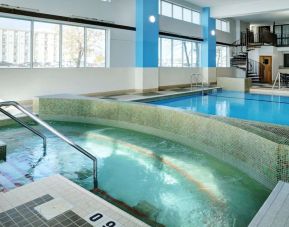 Indoor pool with jacuzzi at Hilton Winnipeg Airport Suites.