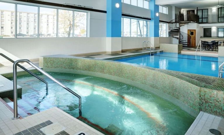 Indoor pool with jacuzzi at Hilton Winnipeg Airport Suites.