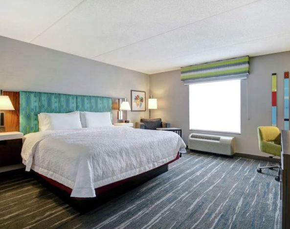 Bright day use room with king bed, work desk and private bathroom at the  Hampton Inn & Suites By Hilton Guelph.