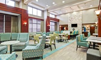 Hotel lounge and dining area with comfortable seating at the  Hampton Inn & Suites By Hilton Guelph.