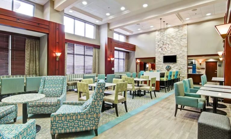 Hotel lounge and dining area with comfortable seating at the  Hampton Inn & Suites By Hilton Guelph.