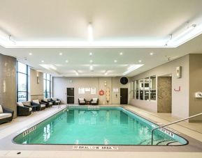 Relaxing indoor pool with lounge chairs at DoubleTree By Hilton Kitchener.