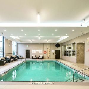 Relaxing indoor pool with lounge chairs at DoubleTree By Hilton Kitchener.