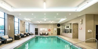 Relaxing indoor pool with lounge chairs at DoubleTree By Hilton Kitchener.