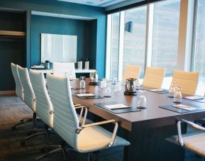 Professional meeting room with large windows, white board and comfortable chairs at the Hilton Garden Inn Fredericton.