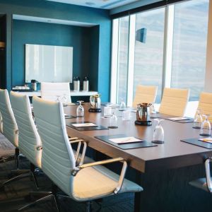 Professional meeting room with large windows, white board and comfortable chairs at the Hilton Garden Inn Fredericton.