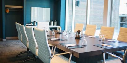 Professional meeting room with large windows, white board and comfortable chairs at the Hilton Garden Inn Fredericton.