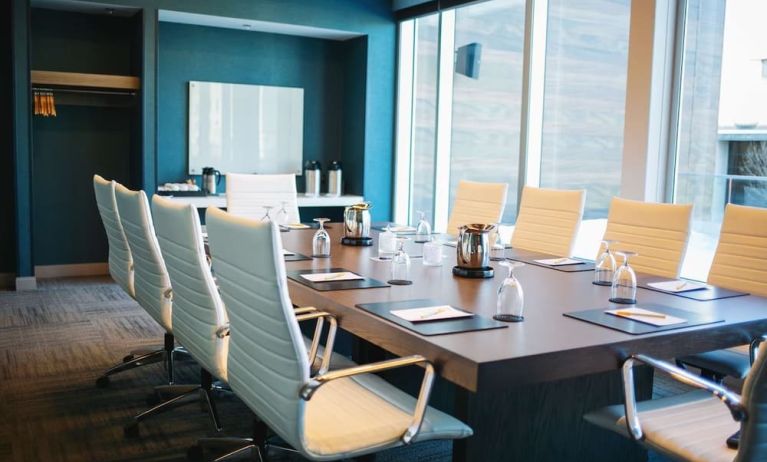 Professional meeting room with large windows, white board and comfortable chairs at the Hilton Garden Inn Fredericton.