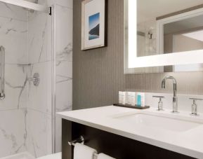 Private guest bathroom with shower and free toiletries at the Embassy Suites By Hilton Toronto Airport.