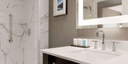 Private guest bathroom with shower and free toiletries at the Embassy Suites By Hilton Toronto Airport.