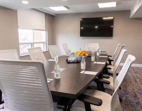 Professional meeting room with TV screen and ergonomic chairs at the Embassy Suites By Hilton Toronto Airport.