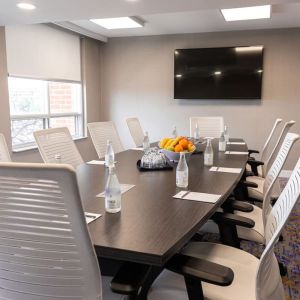 Professional meeting room with TV screen and ergonomic chairs at the Embassy Suites By Hilton Toronto Airport.