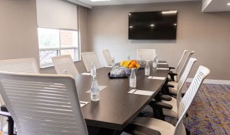 Professional meeting room with TV screen and ergonomic chairs at the Embassy Suites By Hilton Toronto Airport.