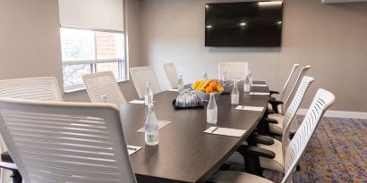 Professional meeting room with TV screen and ergonomic chairs at the Embassy Suites By Hilton Toronto Airport.