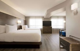 Day use twin room with TV screen, lounge area and work space at the Embassy Suites By Hilton Toronto Airport.