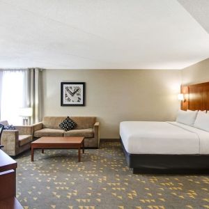 Day use room with TV screen, lounge area, work desk and private bathroom at the Holiday Inn Oakville Centre.