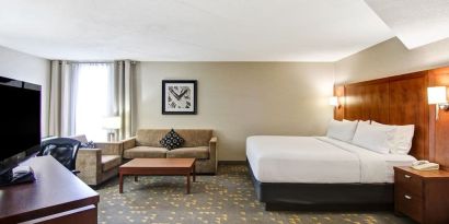 Day use room with TV screen, lounge area, work desk and private bathroom at the Holiday Inn Oakville Centre.