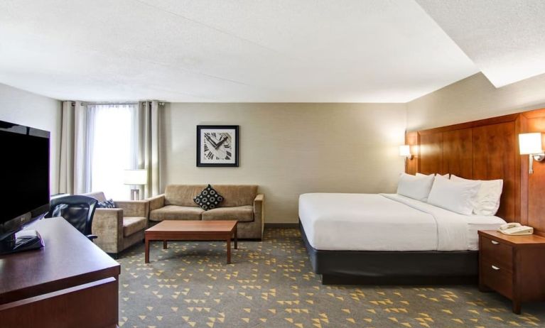 Day use room with TV screen, lounge area, work desk and private bathroom at the Holiday Inn Oakville Centre.