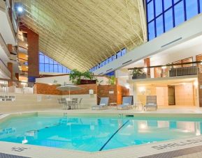 Relaxing indoor pool with lounge chairs at the Holiday Inn Oakville Centre.