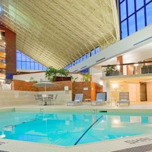 Relaxing indoor pool with lounge chairs at the Holiday Inn Oakville Centre.