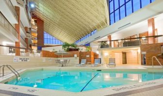 Relaxing indoor pool with lounge chairs at the Holiday Inn Oakville Centre.