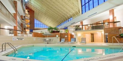 Relaxing indoor pool with lounge chairs at the Holiday Inn Oakville Centre.