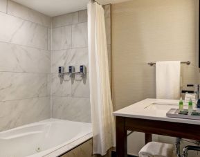 Private guest bathroom with tub and free toiletries at the Four Points By Sheraton St Catharines Niagara Suites.