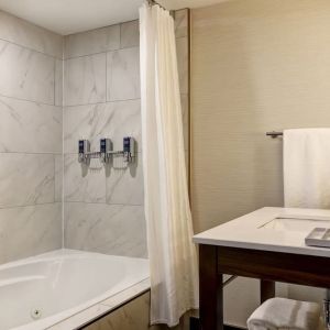 Private guest bathroom with tub and free toiletries at the Four Points By Sheraton St Catharines Niagara Suites.