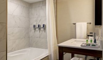 Private guest bathroom with tub and free toiletries at the Four Points By Sheraton St Catharines Niagara Suites.