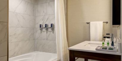 Private guest bathroom with tub and free toiletries at the Four Points By Sheraton St Catharines Niagara Suites.